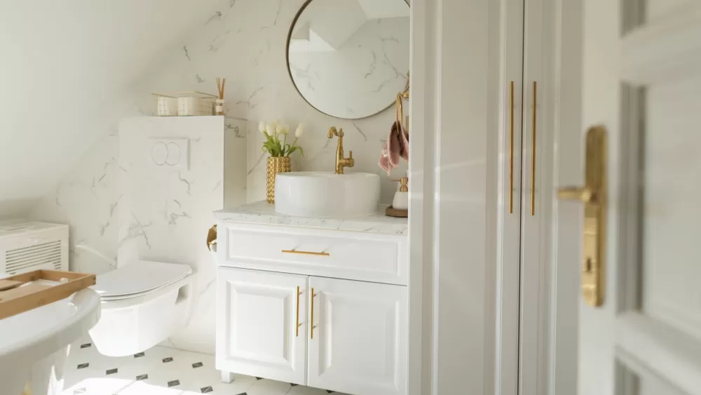 Kupaonica bijele boje sa zlatnim detaljima